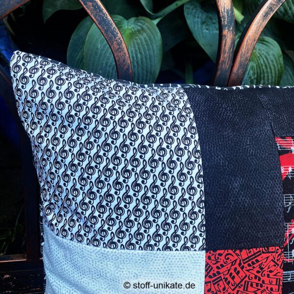 Detailansicht vom Dekokissen "Sonata" mit Notenschlüsseln in schwarz-weiß. Stoff-Unikate handmade in Germany