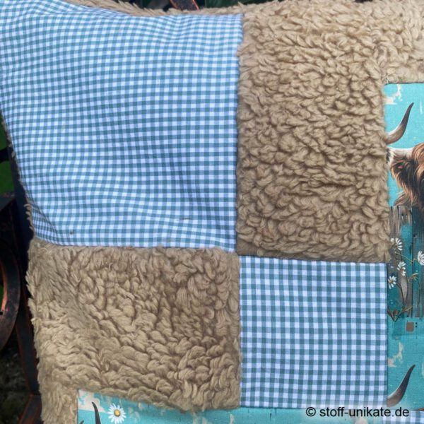 Detailansicht vom Künstlerkissen "Highlander Cows" genäht aus einer Kombination aus Teddyplüsch und grün-karierter Baumwolle. Stoff-Unikat handmade in Germany