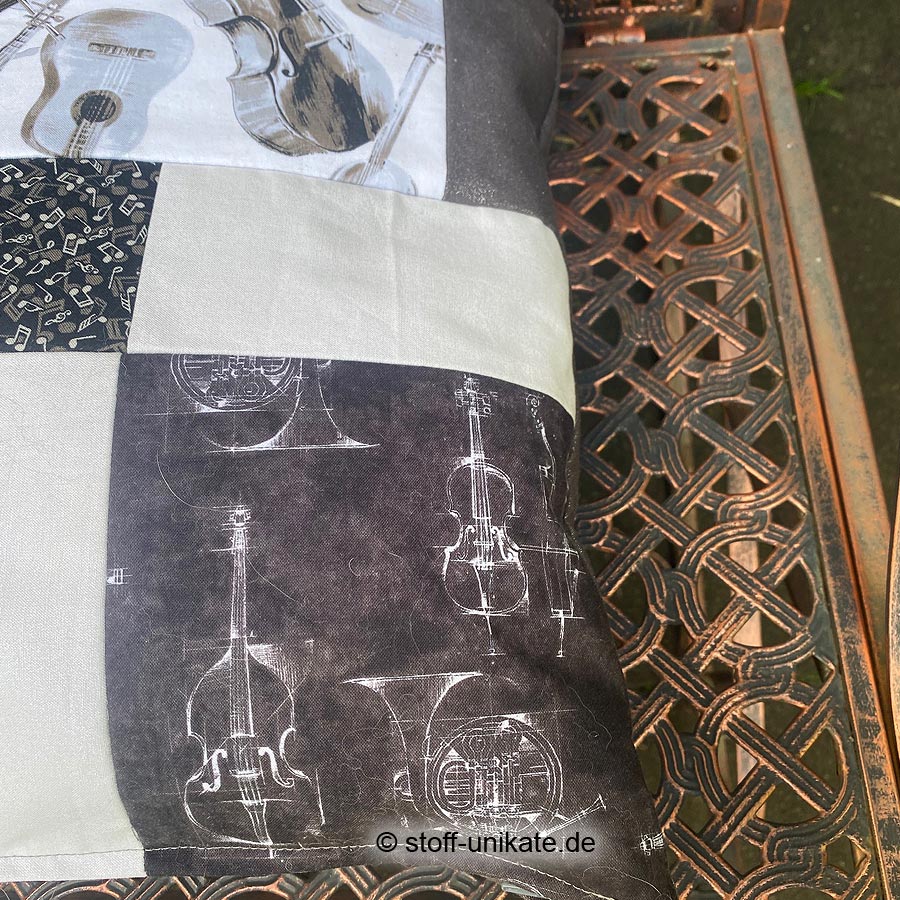Detailansicht vom Dekokissen "Musikinstrumente". Abbbildung von Geigen und Horn. Stoff-Unikate handmade in Germany