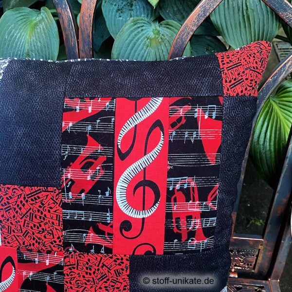 Detailansicht vom Deko-Kissen, Künstlerkissen "Sonata" mit Notenschlüsseln in schwarz-weiß-rot. Stoff-unikate handmade in Deutschland