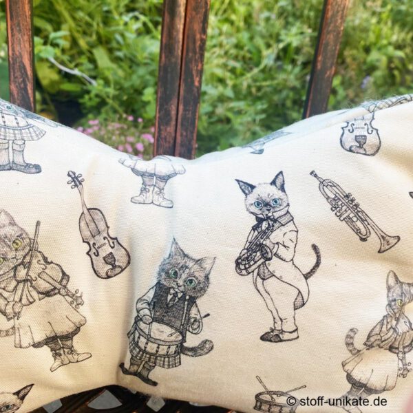 Detailansicht vom Leseknochen "Musikalische Katzen" in creme mit musizierenden Katzen im Schottenrock. Stoff-Unikat handmade in germany