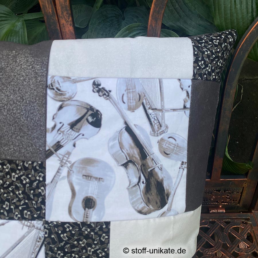 Detailansicht vom Dekokissen "Musikinstrumente". Abbildung von Geigen und Gitarren. Stoff-Unikate handmade in Deutschland