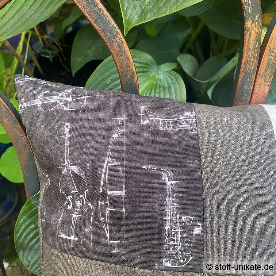 Detailansicht vom Dekokissen "Musikinstrumente". Abbildung von Geigen und Saxophon. Stoff-Unikate handmade in Deutschland