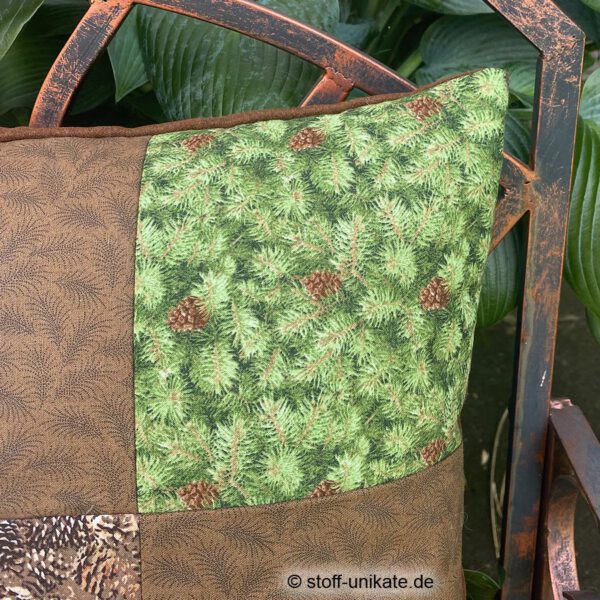 Detailansicht vom Dekokissen mit Waschbären und Tannenzapfen. Stoff-Unikat handmade in Germany