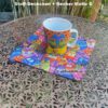 C_Geschenkset bestehend aus Porzellanbecher und Stoffdeckchen mit bunten Katzen. Stoff-Unikate handmade in Germany