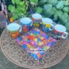 Gruppenfoto vom Geschenk-Set bestehend aus jeweils einem Porzellanbecher und einem Stoff-Deckchen mit Katzenmotiven von Laurel Burch. Stoff-unikate handmade in Germany