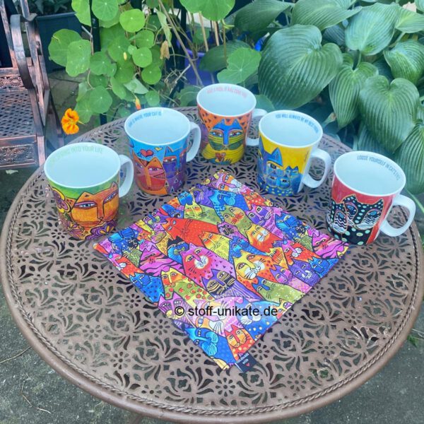 Gruppenfoto vom Geschenk-Set bestehend aus jeweils einem Porzellanbecher und einem Stoff-Deckchen mit Katzenmotiven von Laurel Burch. Stoff-unikate handmade in Germany