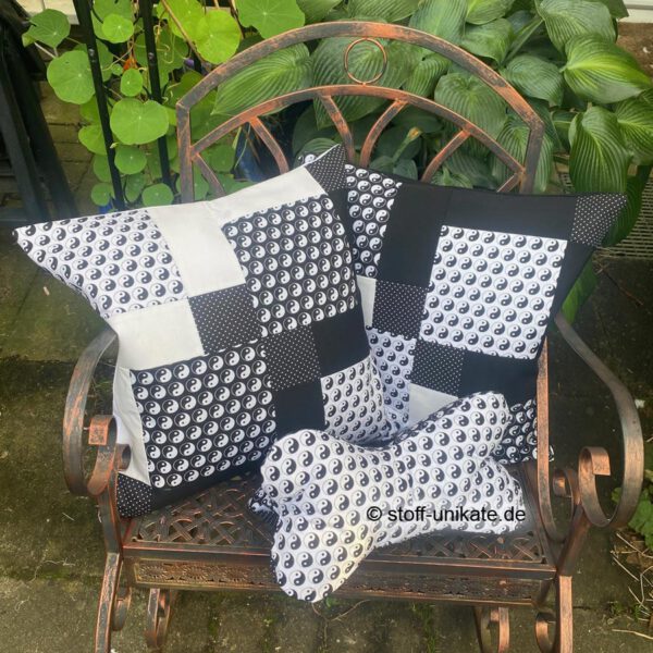 Gruppenfoto aus der Serie Yin Yang mit zwei Dekokissen und einem Leseknochen. Stoff-Unikate handmade in Germany