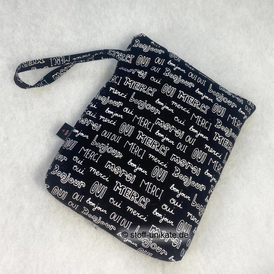 gepolsterte Buchhülle mit Wörtern in schwarz-weiß genäht aus reinen Baumwollstoffen. Stoff-Unikate handmade in Germany