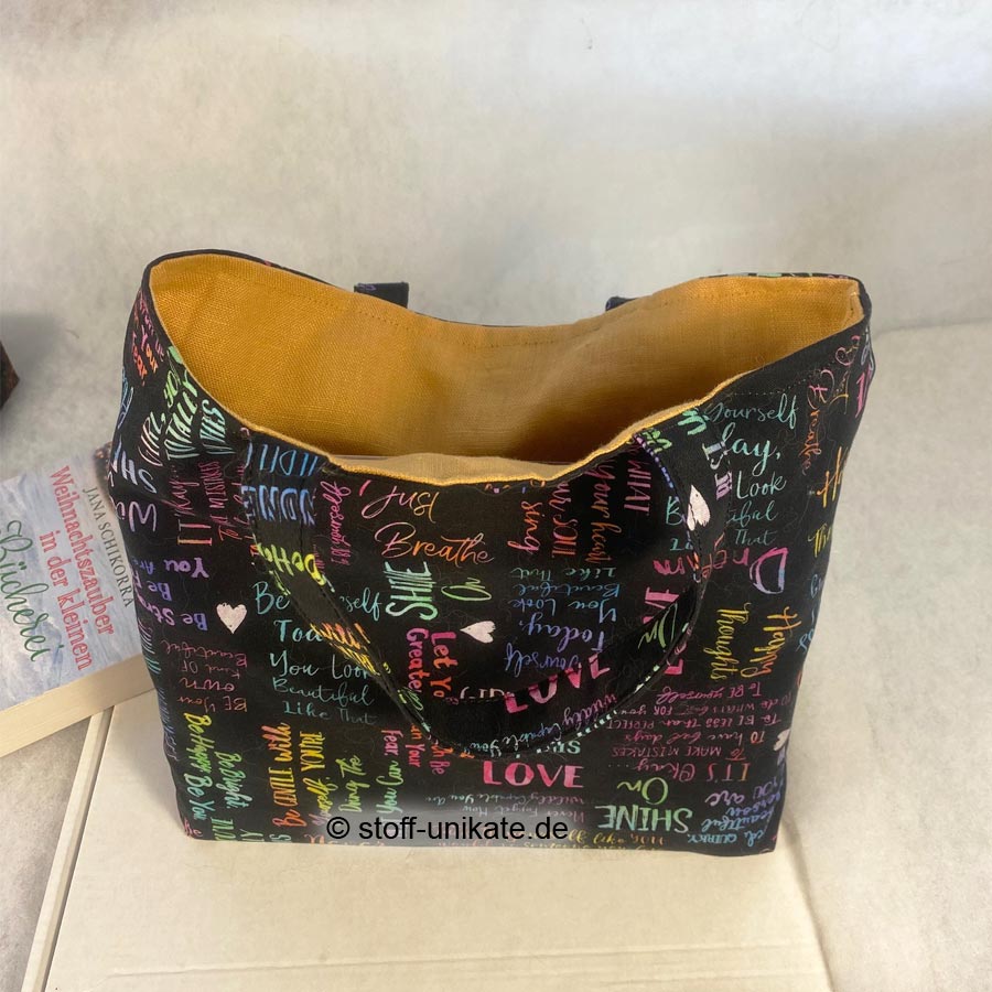 Book bag to Go. Büchertasche für unterwegs genäht aus Baumwollstoffen mit bunter Schrift auf Schwarz. Stoff-Unikate handmade in gerrmany